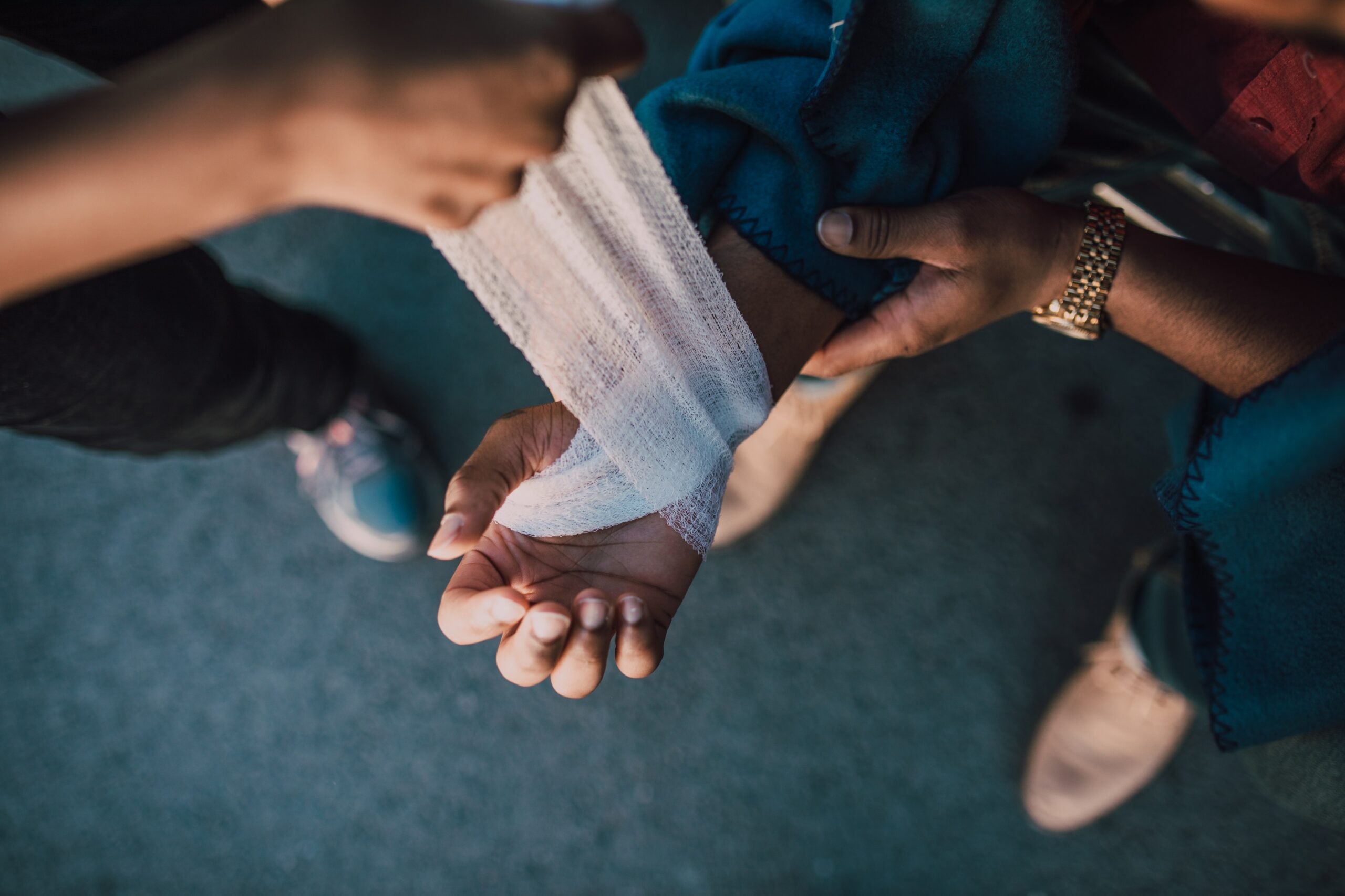 arm being bandaged before a riddor report is filled out for a work place accident 