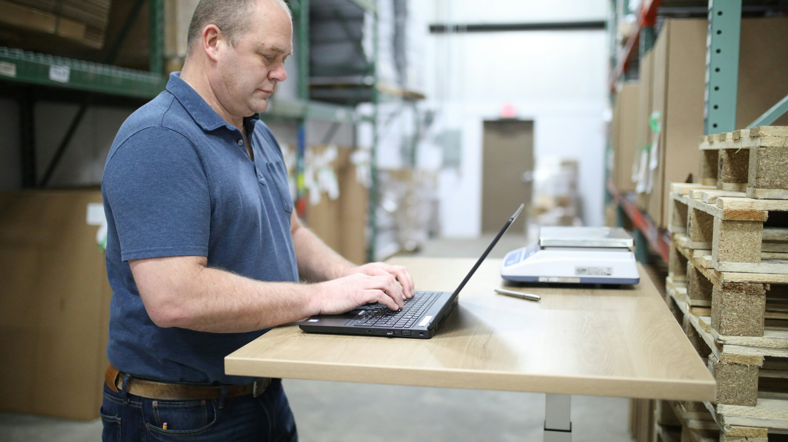 a man in a warehouse completing a warehouse racking inspection